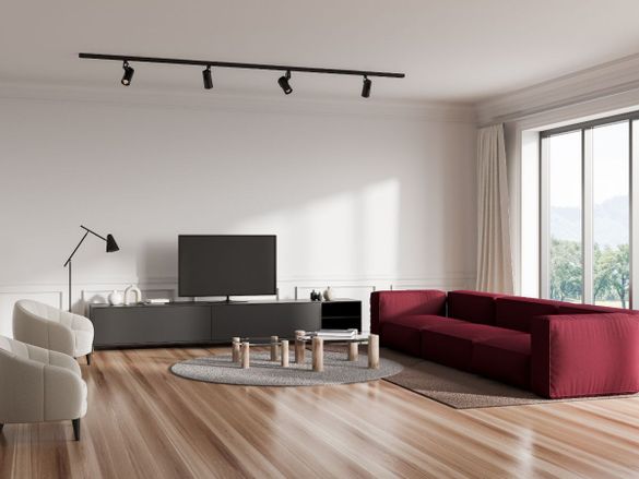 Salón con suelo de madera , y sofa rojo